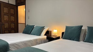 A hotel room with two beds, each with a white bedspread and teal pillows. There is a nightstand with a lamp between the beds. - Camellia House, Tokyo, Zoshigaya, walkable to Ikebukuro station & Sunshine City (豊島区雑司が谷)