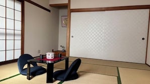 A tatami mat room with a shoji screen, a tatami mat table, two cushions, and a decorative vase. - Camellia House, Tokyo, Zoshigaya, walkable to Ikebukuro station & Sunshine City (豊島区雑司が谷)