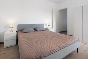Ein Schlafzimmer mit Bett, Nachttischen und einem Kleiderschrank.