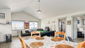A dining area with a pool table, wooden chairs, and a tablecloth with a sea theme. - Break Point Cottage | Canal-Front Stay w/ Pool Table Fun (Rockport)