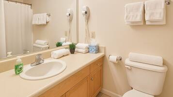 Een haardroger, handdoeken, zeep, toiletpapier