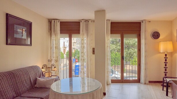 A living room with a sofa, a glass table, a lamp, and a view through the glass doors. - Apartment 'Luque Un Pueblo Con Encanto' with Balcony, Wi-Fi and Air Conditioning (Luque)