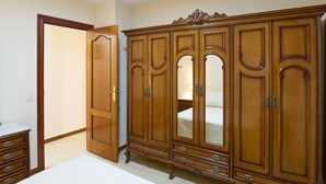 A bedroom with a wooden wardrobe, a bed, and a dresser. - Apartment 'Luque Un Pueblo Con Encanto' with Balcony, Wi-Fi and Air Conditioning (Luque)