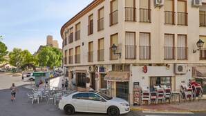 A building with multiple balconies, outdoor seating, and a parked car. - Apartment 'Luque Un Pueblo Con Encanto' with Balcony, Wi-Fi and Air Conditioning (Luque)