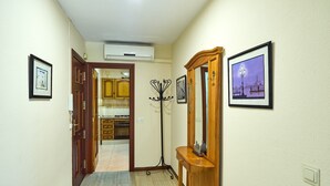 A hallway with a wooden door, a coat rack, and framed pictures on the walls. - Apartment 'Luque Un Pueblo Con Encanto' with Balcony, Wi-Fi and Air Conditioning (Luque)
