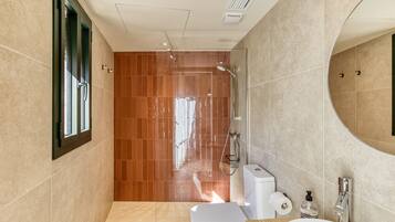 Een moderne badkamer met douche, toilet en wastafel.