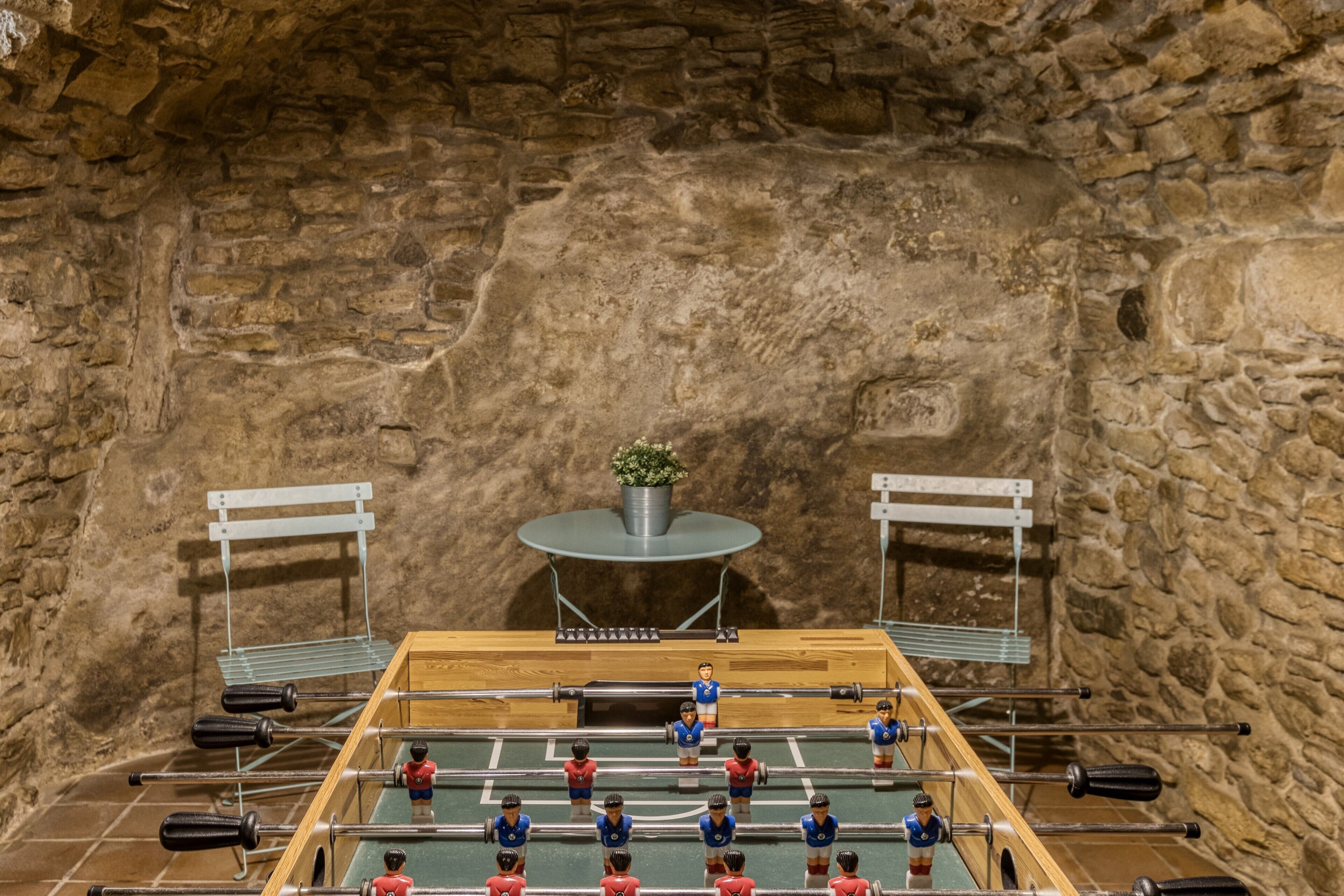 Una mesa de fútbol de mesa frente a un fondo de pared de piedra.