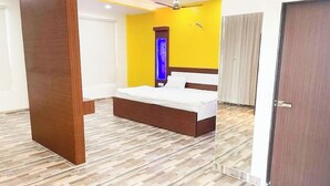 Un dormitorio con cama, suelo de madera y una puerta.