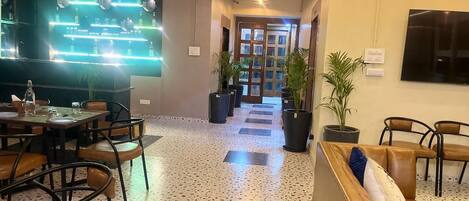 A modern interior with a dining area, seating, and a hallway leading to a door.