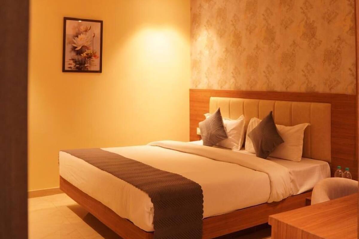 Un dormitorio con cama, ventilador de techo, un cuadro en la pared y cabecera de madera.