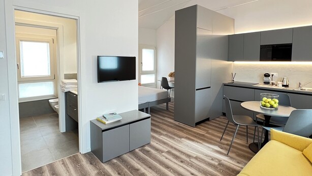Un appartement moderne comprenant une cuisine, un coin repas et un salon.