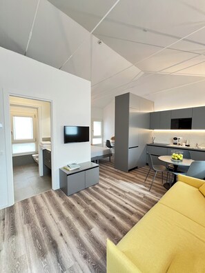 Un appartement moderne comprenant une cuisine, un coin repas et un salon.