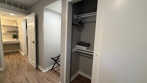 A hallway with a closet, a shelf with folded clothes, and a chair. - Central to Zoo and Baxter Arena, Pet Friendly (Omaha)