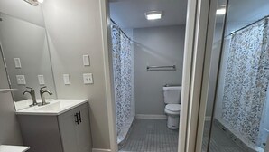 Ein kleines Badezimmer mit Waschbecken, Spiegel und Toilette.