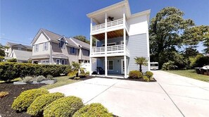 A two-story residential building with a balcony on the upper floor, a garage, and a well-maintained front yard with shrubs. - Beautiful 4-bedroom home in tranquil Virginia Beach (Virginia Beach)