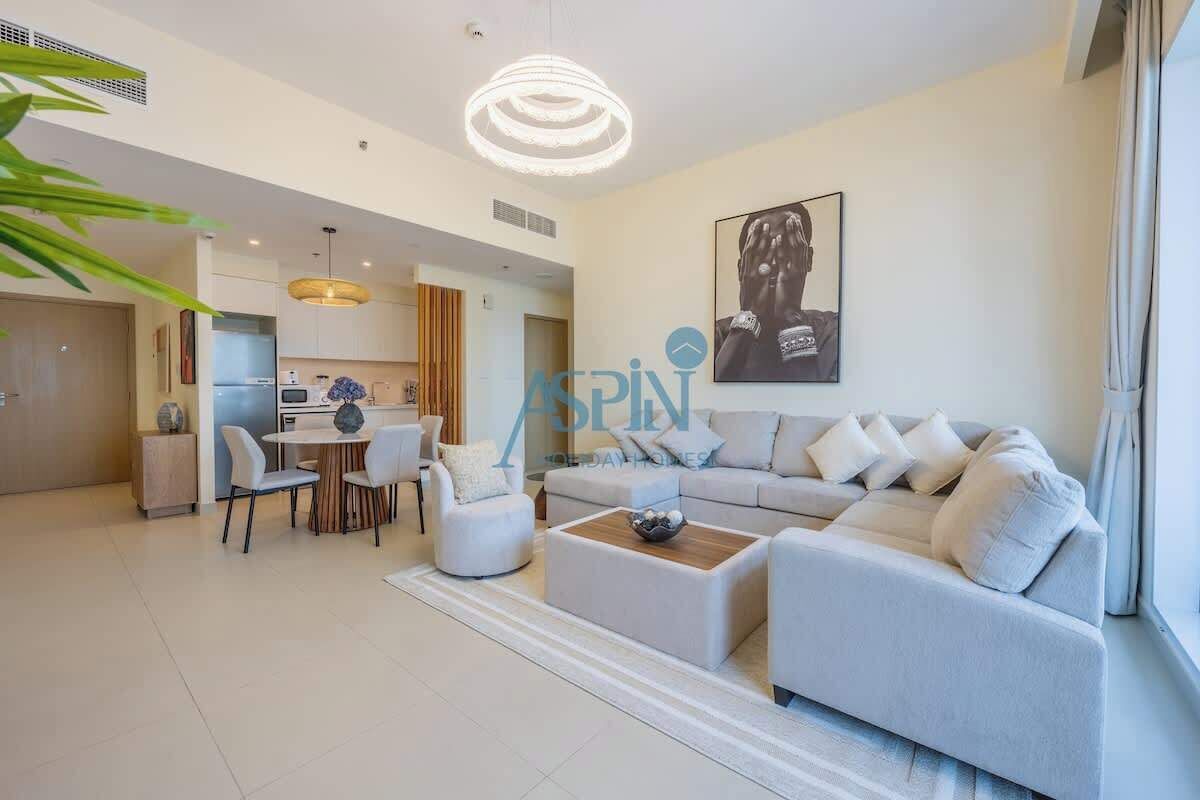 A modern living room with a sofa, chairs, a coffee table, and a dining area with a table and chairs.