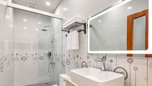 Ein modernes Badezimmer mit einem großen Spiegel, einer Badewanne und einer Toilette.