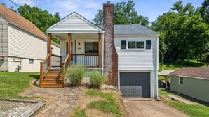 A single-story house with a front porch, a brick chimney, and a garage. - Peaceful Plum PA Home (Pittsburgh)