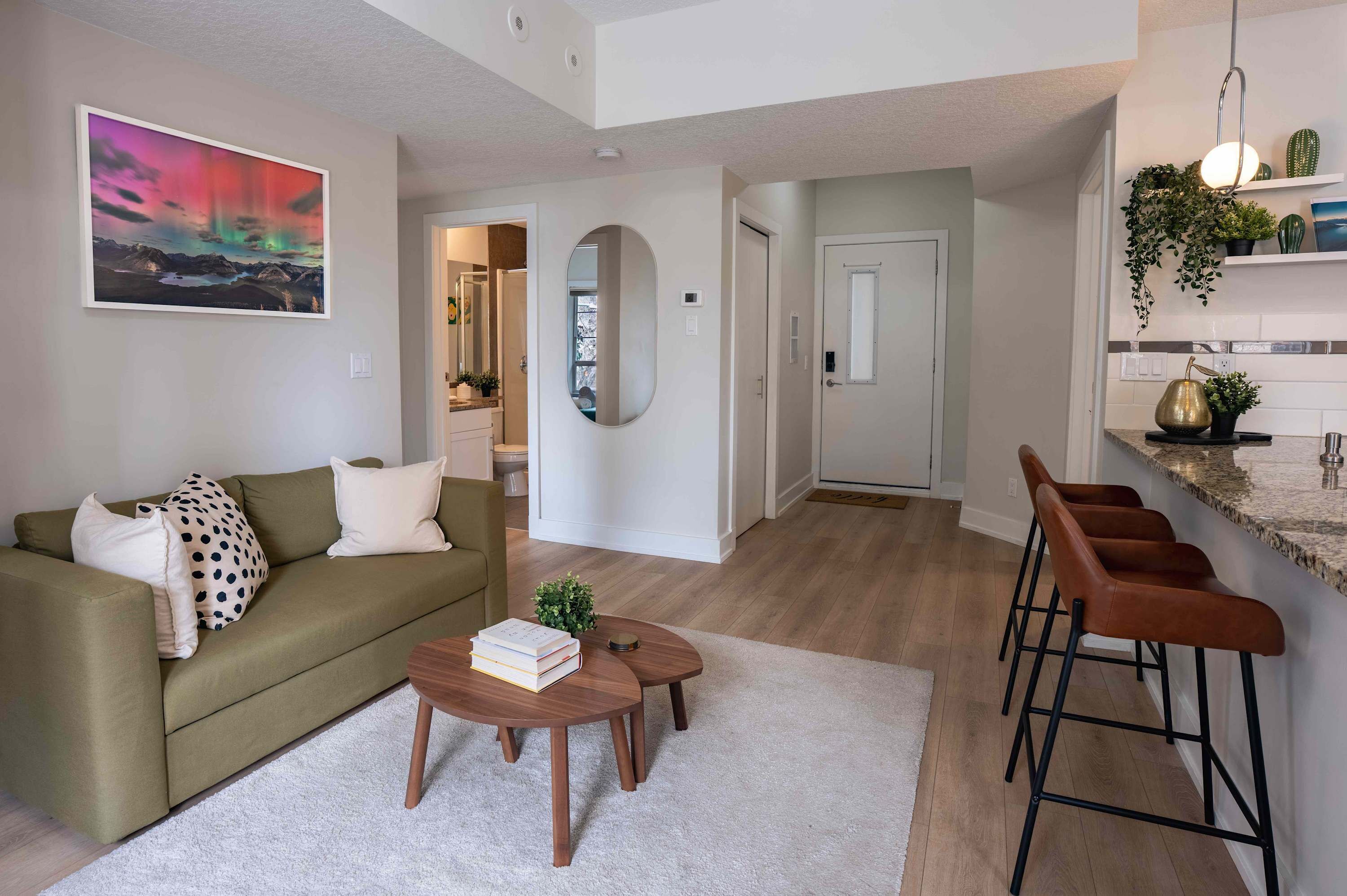 En moderne stue med sofa, sofabord og barstole.