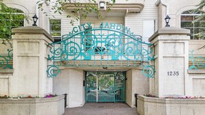 A gated entrance with a decorative metal archway and a building number 1235. - 13th Ave Condo + City Views + Balcony + Walkable (Calgary)