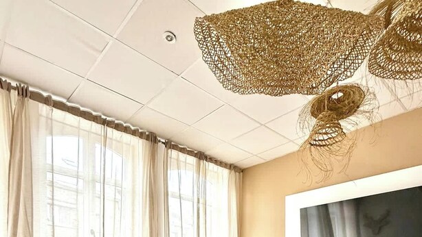 Een moderne woonkamer met een bank, fauteuils, een salontafel en een televisie.