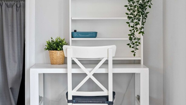 A white desk with a blue lamp, a wicker basket, and a potted plant. - Local Loft Downtown Okotoks 2BD Private (Okotoks)