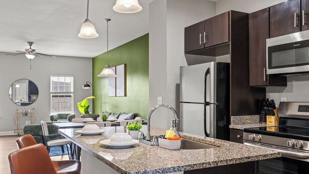 A modern kitchen with granite countertops, stainless steel appliances, and dark wooden cabinets. - Upscale King 3BR Townhouse in Pineville (Pineville)