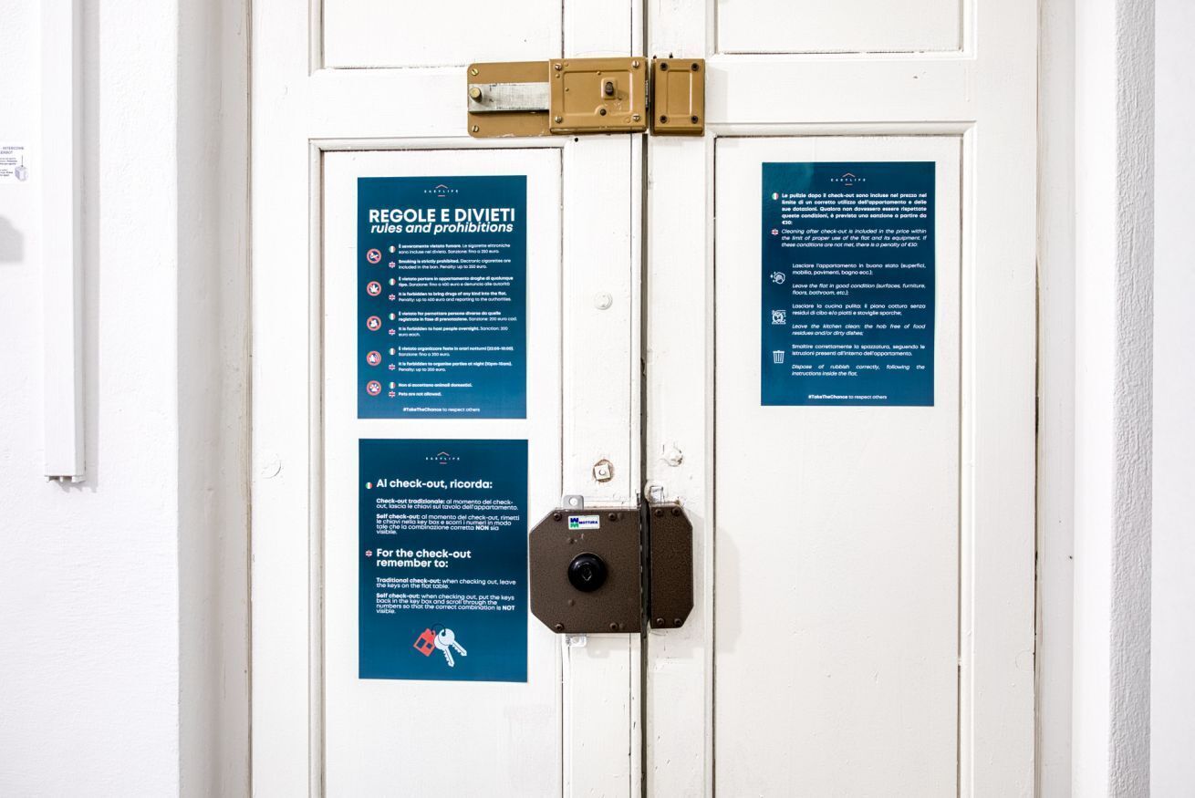A door with two blue signs detailing rules and prohibitions.