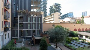 Un patio central con jardín, rodeado por edificios residenciales de varios pisos con balcones y terrazas.