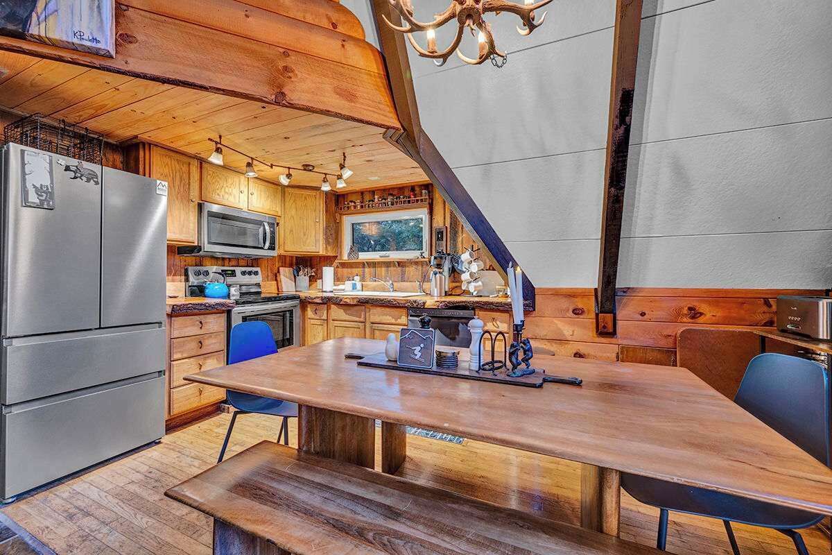 A modern kitchen with wooden cabinetry, stainless steel appliances, and a large island with seating.