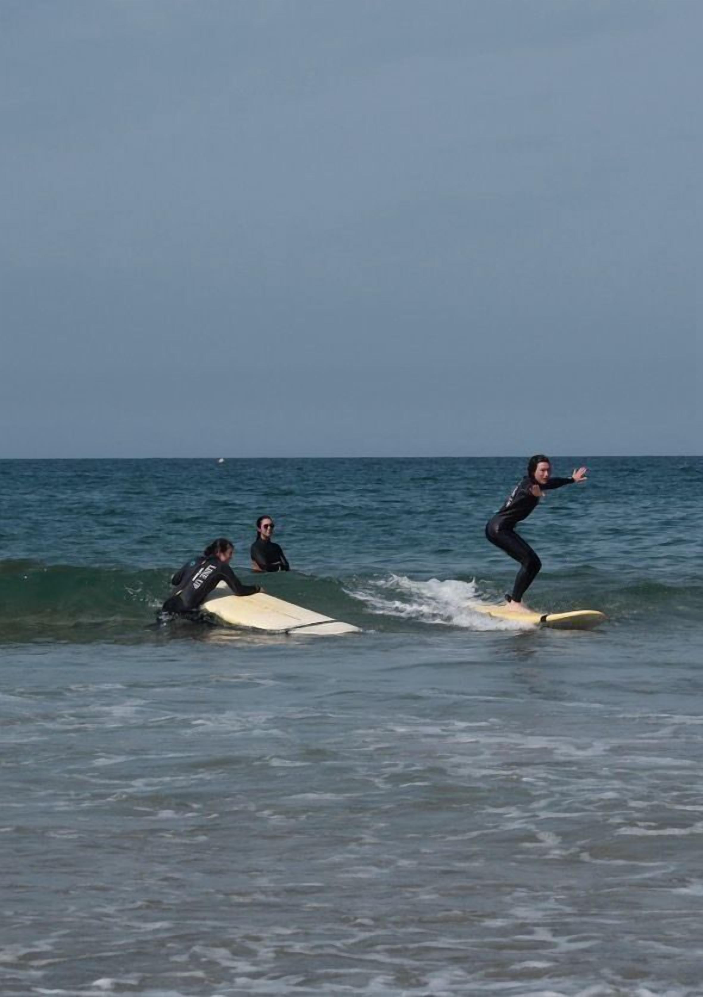 Three people surfing on the ocean.