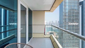Een balkon met uitzicht op een stadsgezicht, inclusief een gebouw met de naam "DAMAC".