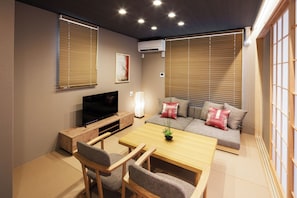 A modern living room with a flat-screen TV, sofa, and wooden furniture. - Cityzen Tokyo (Tokyo)
