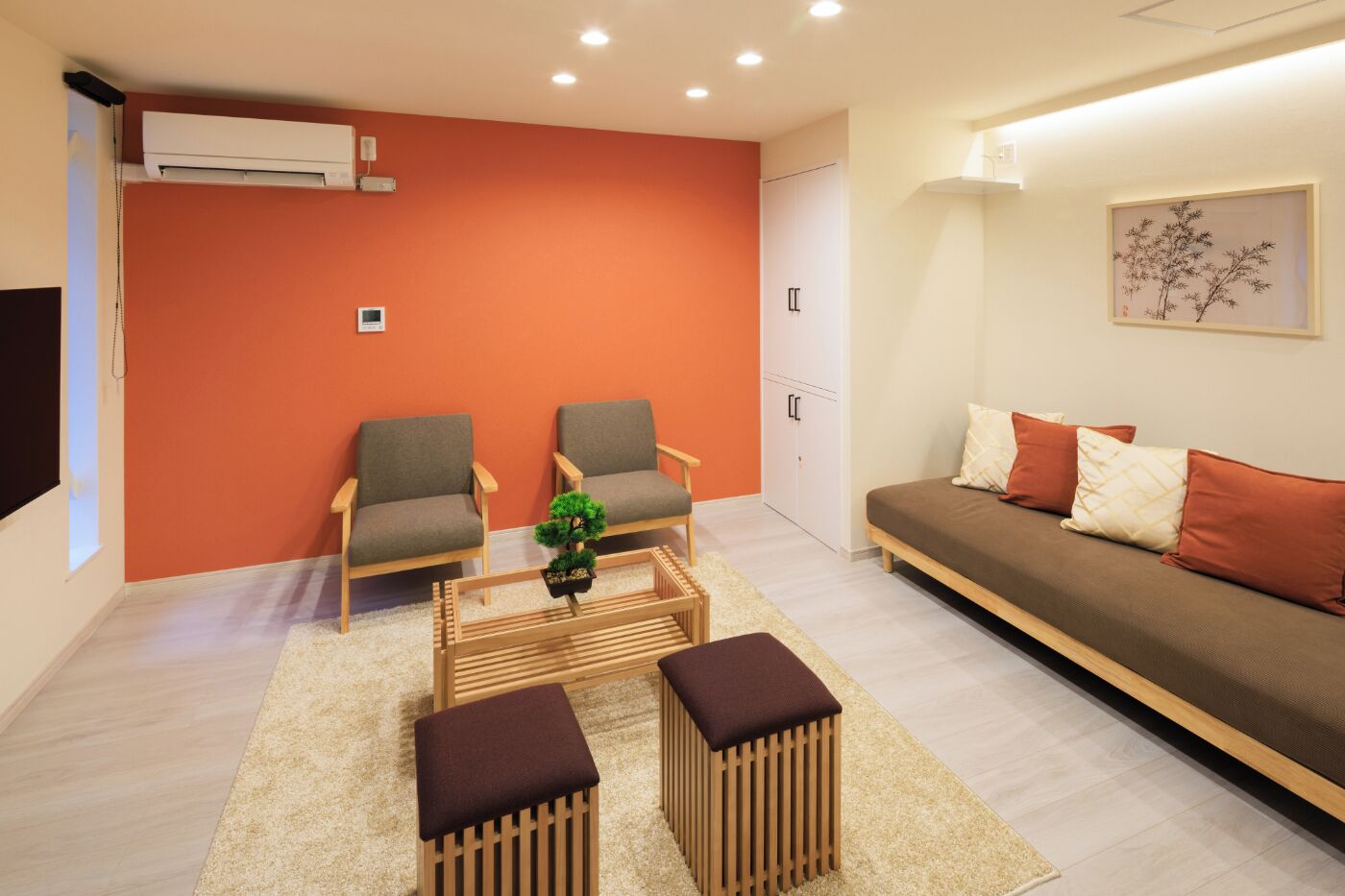 A modern living room with two armchairs, a sofa, a coffee table, and a small potted plant.