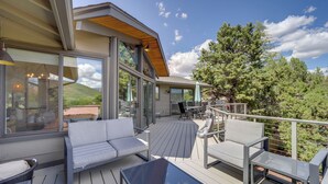 A deck with outdoor furniture, large windows, and a view of trees and hills. - Walk to Park & Trails! Mtn-view Sedona Haven (Sedona)