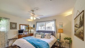 A bedroom with a bed, a ceiling fan, a television, a lamp, and a window with curtains. - Home w/ Backyard Oasis < 7 Mi to At&t Stadium! (Euless)