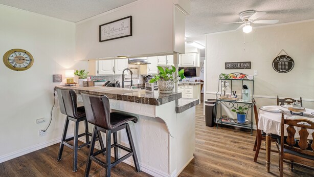 A modern kitchen with a central island, bar stools, and a coffee bar. - Home w/ Backyard Oasis < 7 Mi to At&t Stadium! (Euless)