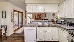 A kitchen with white cabinets, a refrigerator, a microwave, and a sink. - Home w/ Backyard Oasis < 7 Mi to At&t Stadium! (Euless)