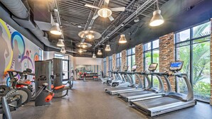 A gym with treadmills, weight machines, and a colorful mural on the wall. - Fall Family Fun Near Disney! Resort Perks & Golf (Davenport)