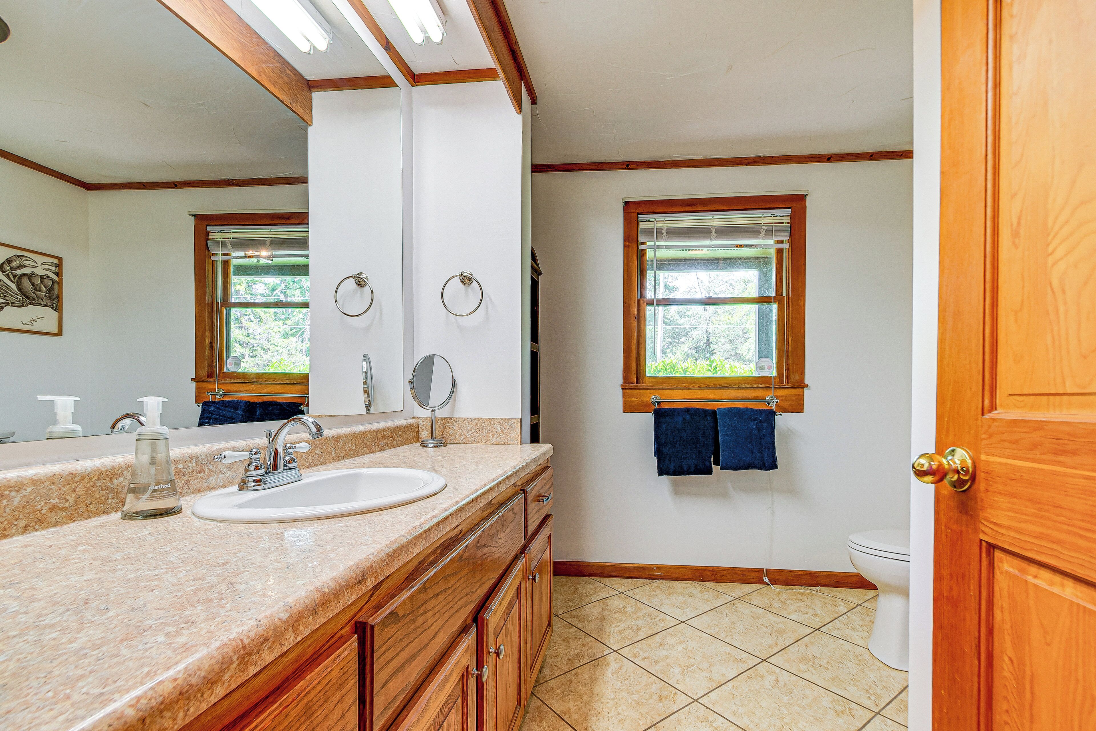 A bathroom with two sinks, a mirror, and a toilet.