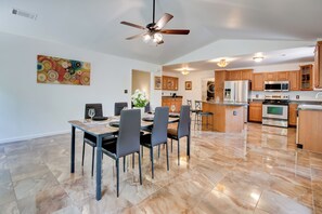 A modern kitchen with wooden cabinets, stainless steel appliances, and a dining area with a table and chairs. - Unwind, Golf & Explore: Unique Atlanta Escape! (Atlanta)