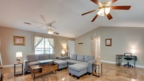 A spacious living room with a sectional sofa, a coffee table, and a ceiling fan. - Unwind, Golf & Explore: Unique Atlanta Escape! (Atlanta)
