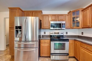 A kitchen with stainless steel appliances, wooden cabinets, and a granite countertop. - Unwind, Golf & Explore: Unique Atlanta Escape! (Atlanta)