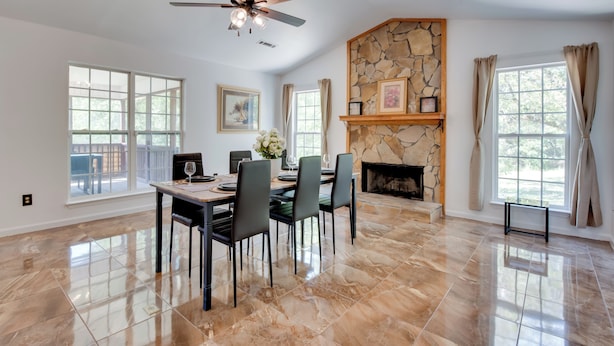 A spacious dining area with a stone fireplace, large windows, and a ceiling fan. - Unwind, Golf & Explore: Unique Atlanta Escape! (Atlanta)