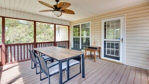 A covered porch with a wooden table and chairs, a ceiling fan, and a sliding glass door. - Unwind, Golf & Explore: Unique Atlanta Escape! (Atlanta)
