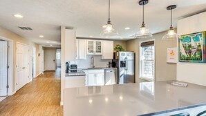 A modern kitchen with a central island, pendant lighting, and a view to the dining area. - Walk to Academy: Lake Max Family Penthouse (Culver)