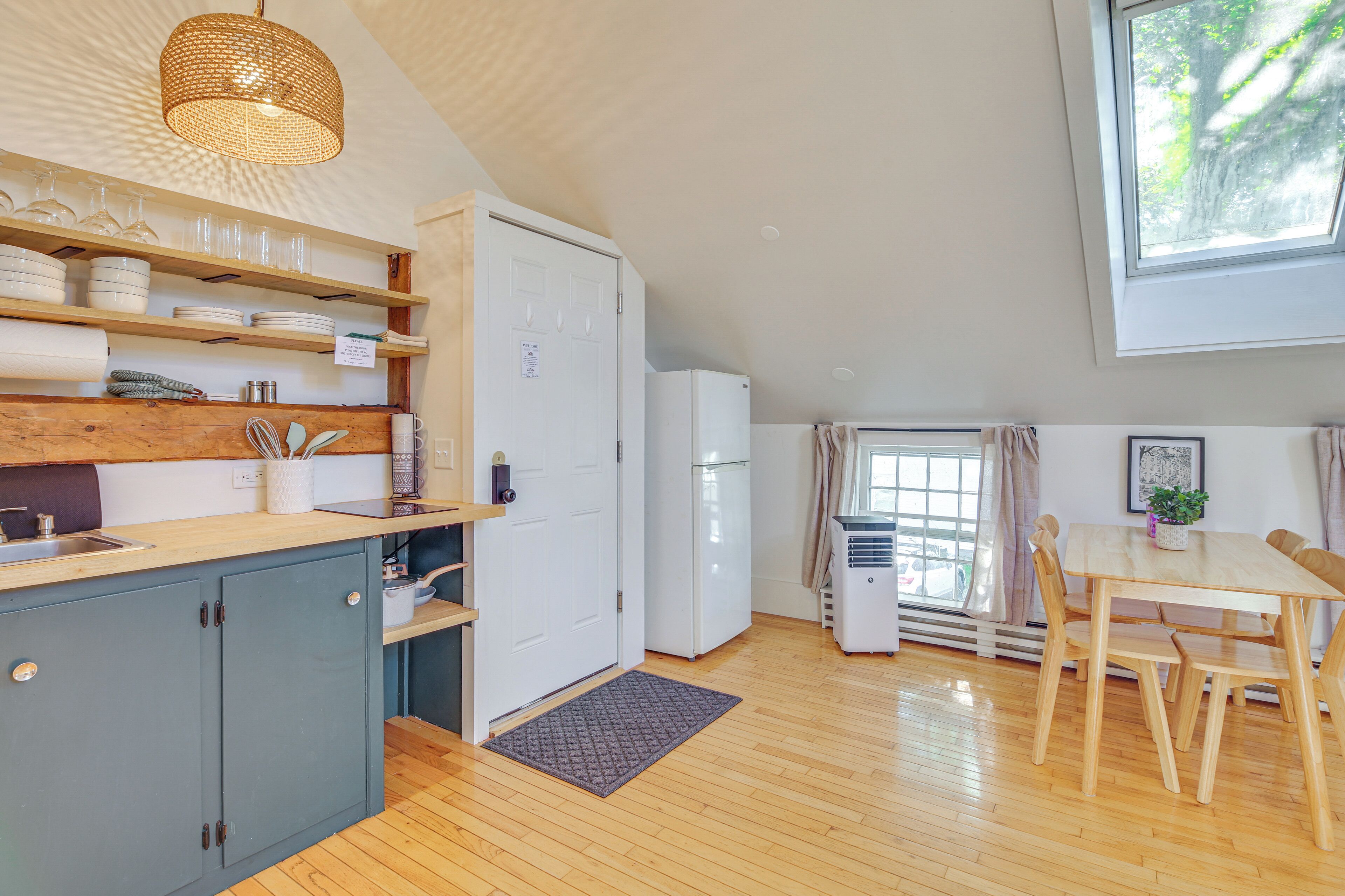 Une cuisine compacte dotée de meubles en bois, d’un évier encastré et d’un coin repas avec une table et des chaises.