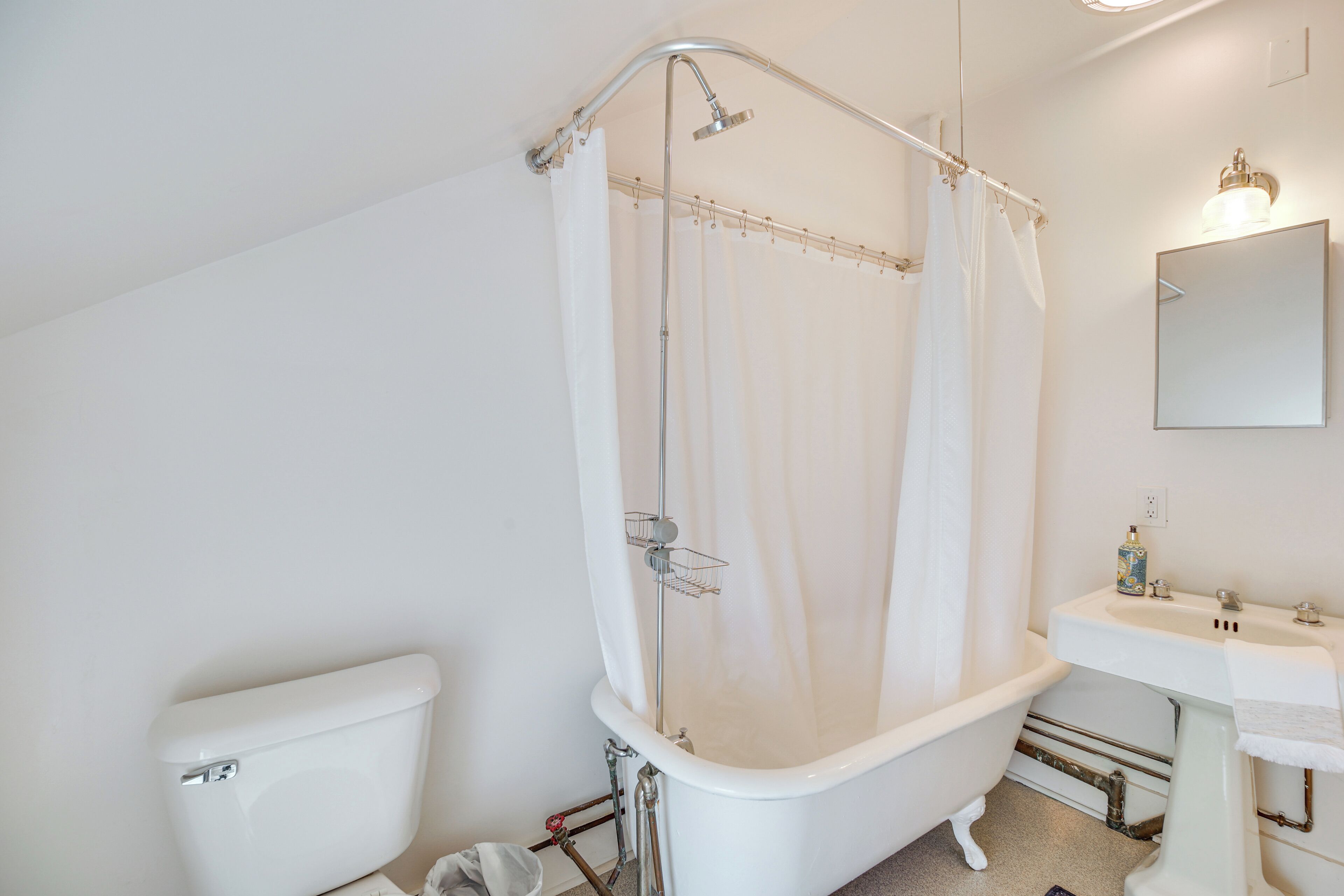 Ein Badezimmer mit einer weißen Badewanne, einer weißen Toilette und einem Waschbecken mit Spiegel darüber.
