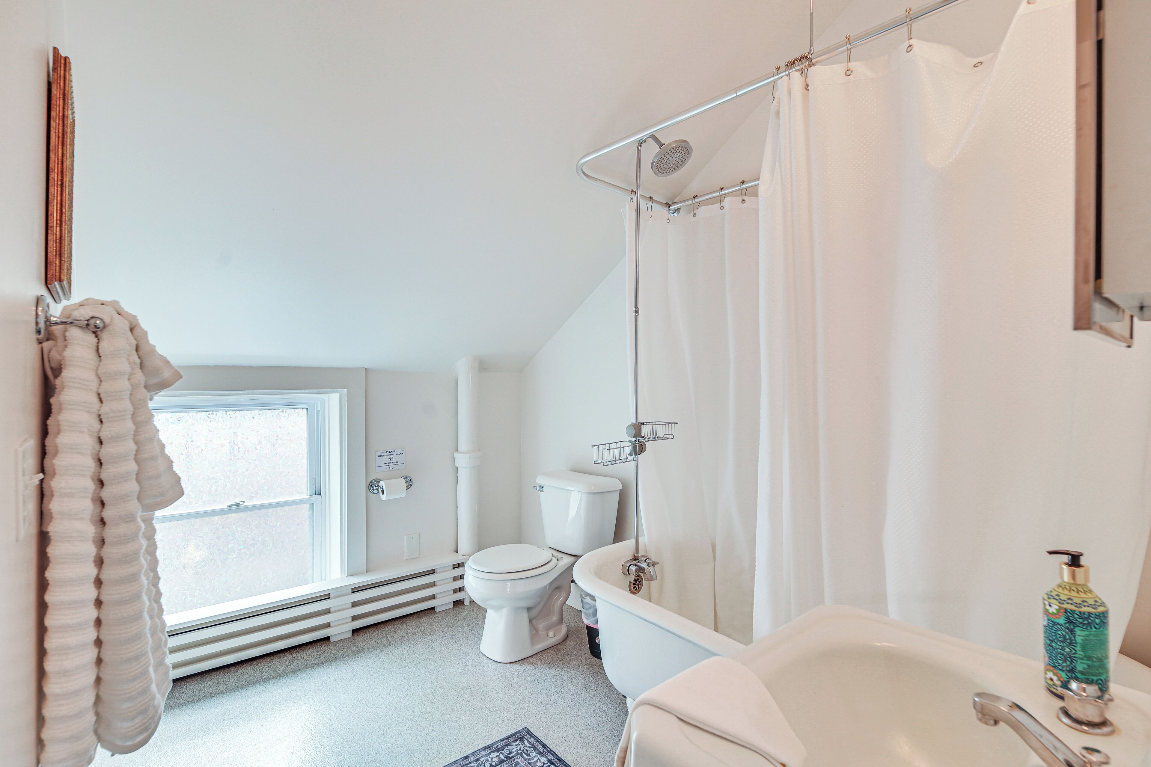 A bathroom with a toilet, bathtub, and shower curtain.