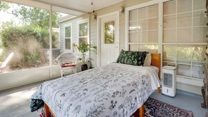 A bedroom with a bed, a ceiling fan, a window with blinds, a chair, and a radiator. - Golf Course Community Home Near Springs & Swimming (Alachua)